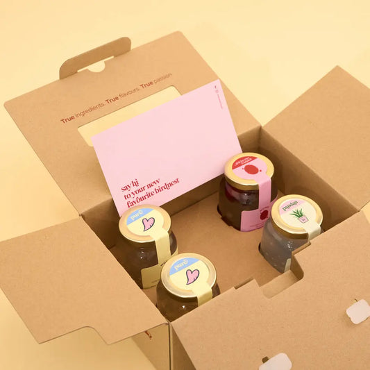 Box of 4 jars freshly boiled birdnest with decorative lids on a yellow background