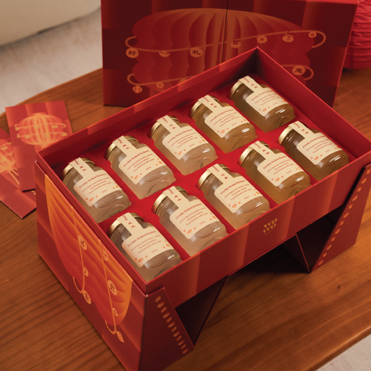 Set of small bottles in a red gift box on a wooden surface